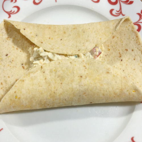 A tortilla on a plate with the ends rolled up