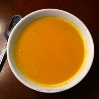 Photo of Pumpkin Soup in a white bowl on a dark wood table
