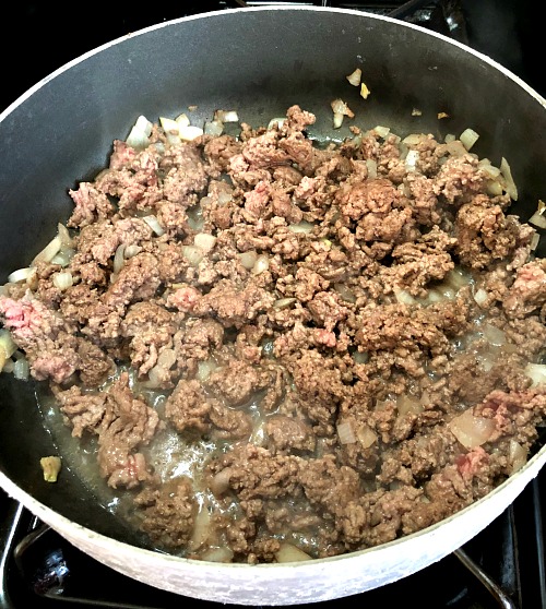 photo of ground beef and onions cooking in a frying pan