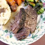 Photo of plated Slow Cooker French Onion Roast Beef with mashed potatoes sliced carrots brussels sprouts and gravy