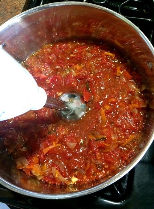 Photo of Slow Cooker Marinara Sauce being purred by an immersion blender