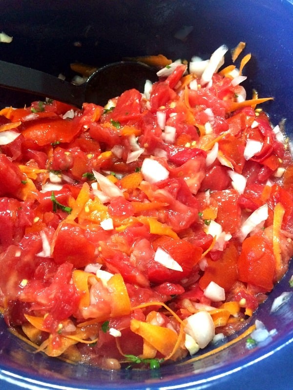 photo of crushed tomatoes, diced onions, shredded carrots, and minced garlic in a blue slow cooker pot