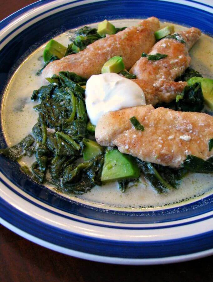 Skillet Chicken with Spinach and Avocado- Turn ordinary chicken tenders into a full meal your family will love with this Skillet Chicken with Spinach and Avocado! Tender chicken, sauteed spinach, diced avocado, simmered in chicken broth and finished with just a little bit of sour cream. Full of protein, iron, and healthy fats, this delicious dinner is ready in less than 30 minutes.