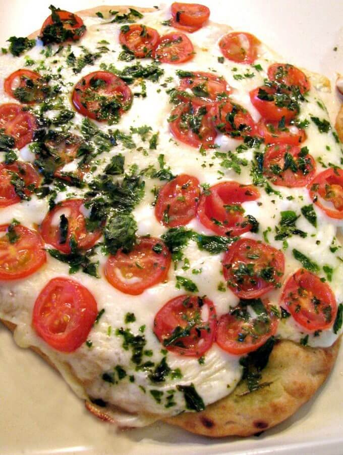 Photo of Margherita Naan Pizza on a light colored baking sheet.