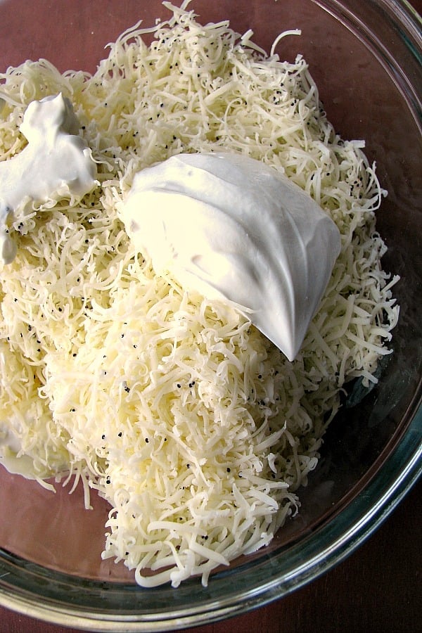 Photo of softened cream cheese, shredded Cabot's Everything Bagel cheddar cheese and sour cream in a clear bowl