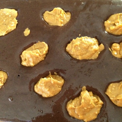 Photo of prepared cake mix topped with spoonfuls of pumpkin cream cheese mixture 