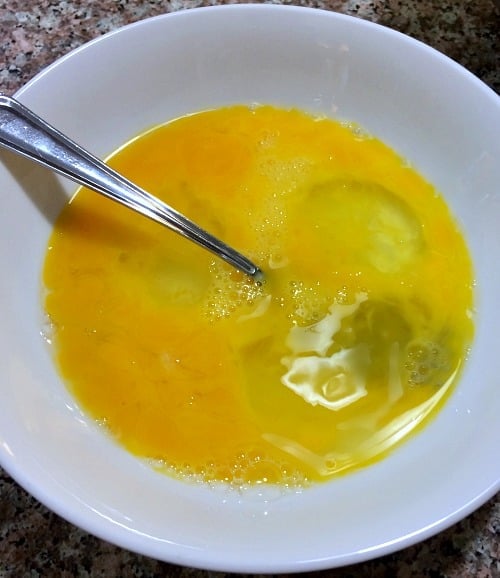 Photo of beaten eggs in a white bowl 