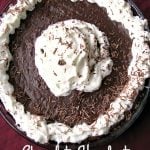 Photo of a whole Chocolate Hazelnut Truffle Tart topped with whipped cream and shaved chocolate