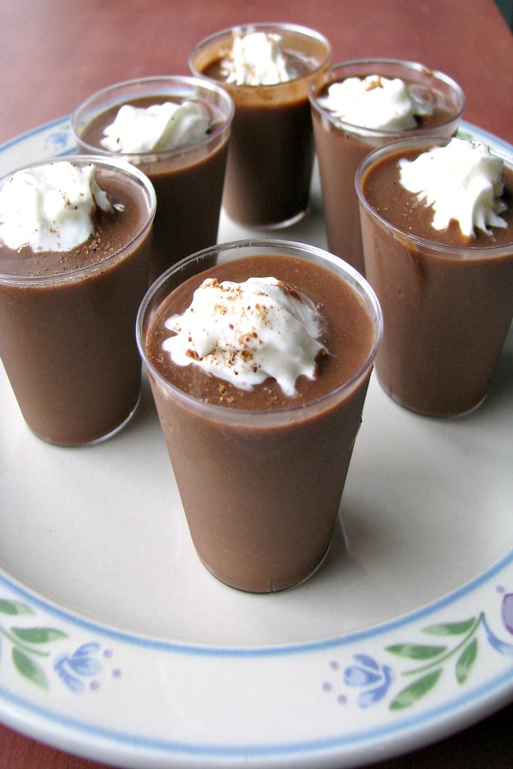 Close up photo of Chocolate Eggnog Pudding Shots on a white plate with flower trim 