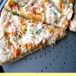 Photo of baked Homemade Crab Rangoon Pizza on a round pizza pan with the lower slices removed