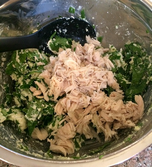 Photo of chicken and spinach topped ricotta cheese in a metal bowl