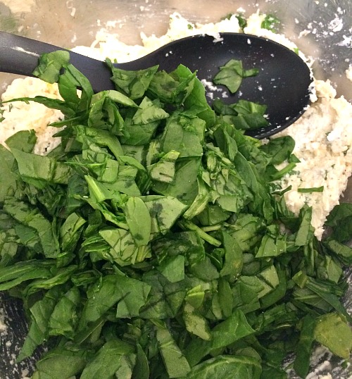 Photo of spinach topped ricotta cheese in a metal bowl