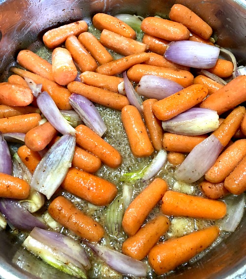Photo of carrots garlic and shallots sauteing in a deep skillet