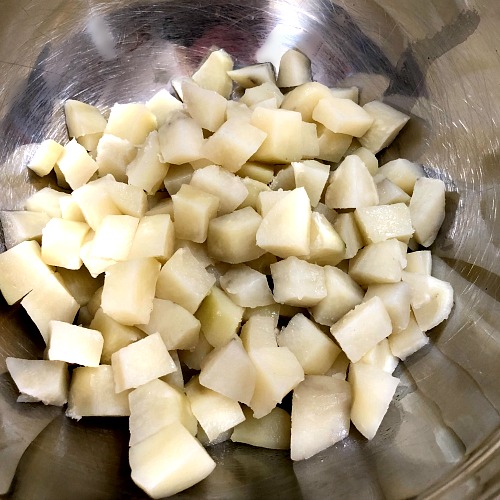 photo of cooked diced potatoes in a metal bowl 