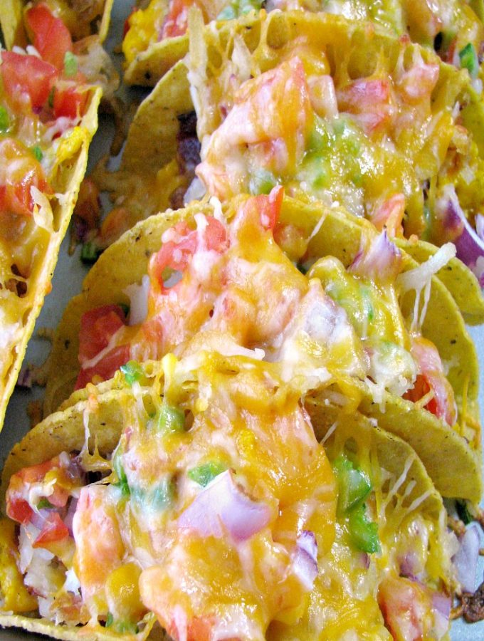 Close up photo of Cheesy Baked Breakfast Tacos on a baking sheet.
