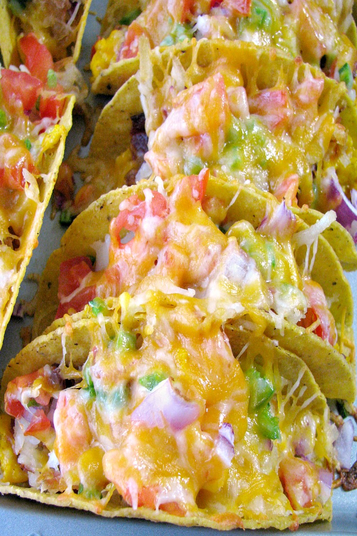 Close up photo of Cheesy Baked Breakfast Tacos on a baking sheet. 