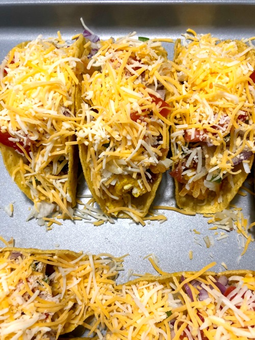 photo of cheese topped breakfast tacos. 