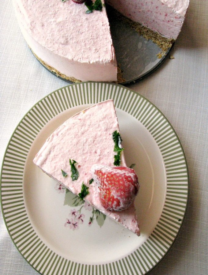 photo of sliced Frozen Strawberry Yogurt Pie on a plate next to the whole pie