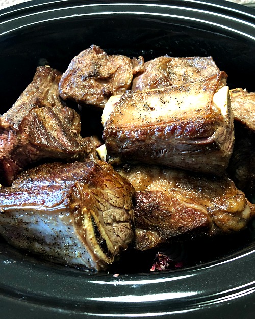 photo of browned short ribs in a slow cooker