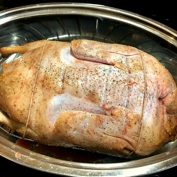 Photo of a whole duck breast side down after one hour of baking 