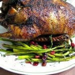 photo of Crispy Roast Duck on a platter with asparagus and roasted cranberries