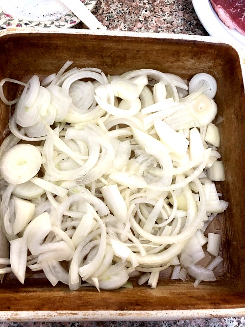 photo of sliced onions in a square baking dish 