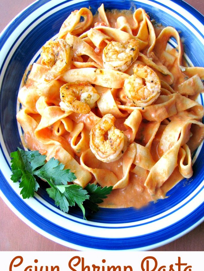 photo of a blue rimmed plate of Cajun Shrimp Pasta with pappardelle pasta and creamy tomato sauce
