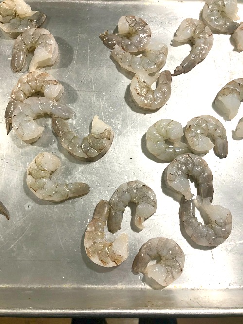photo of raw shrimp on a baking sheet 