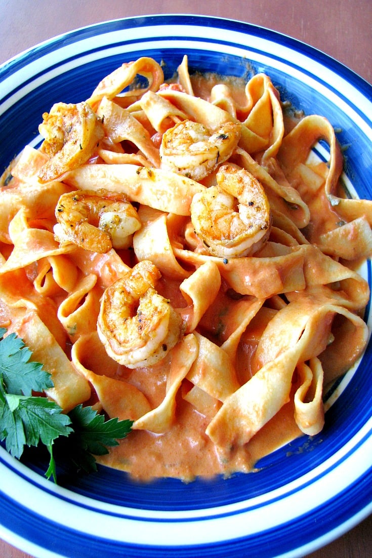Close up photo of plated Cajun Shrimp Pasta on a blue rimmed plate 