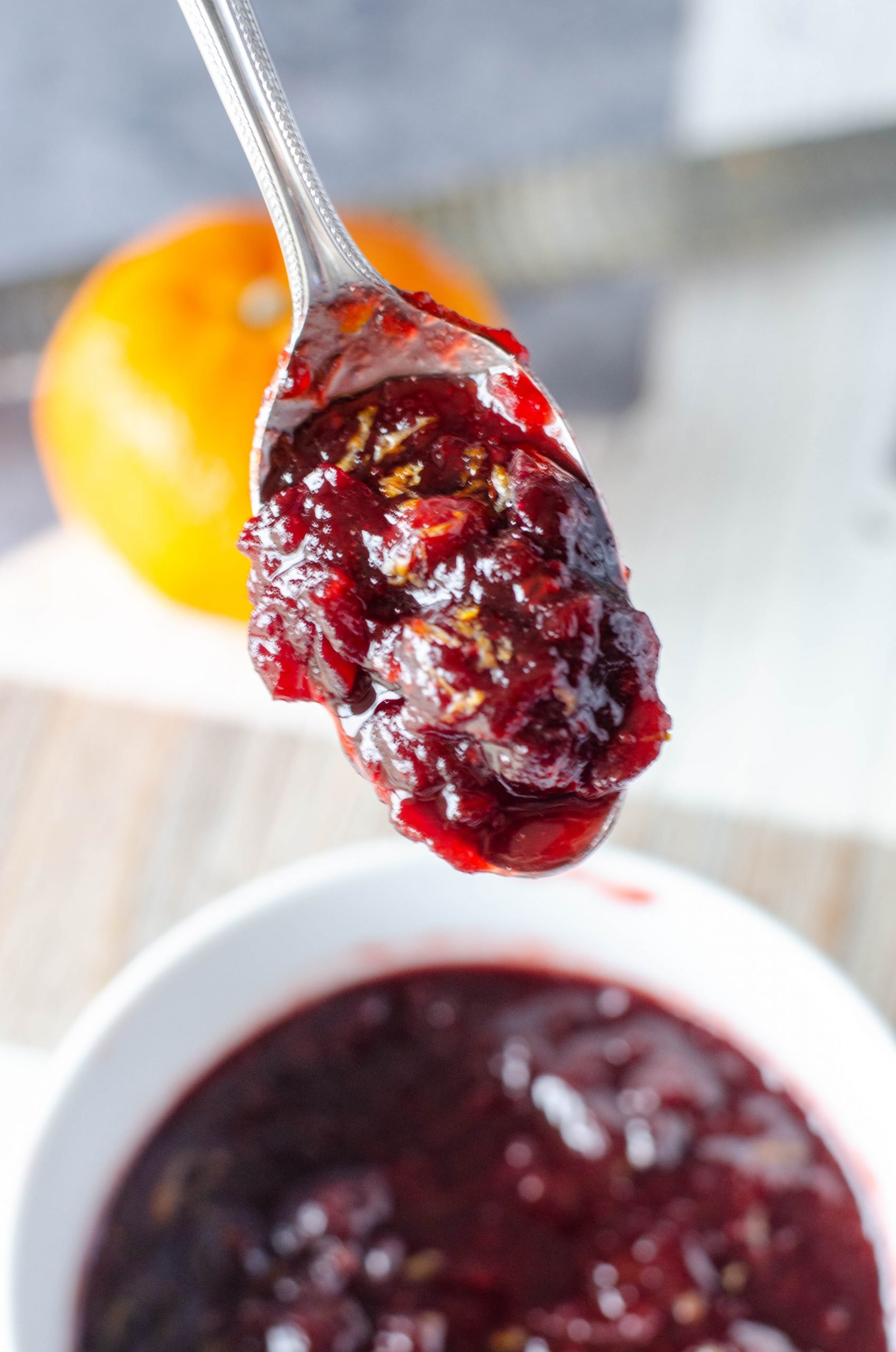 photo of cranberry sauce on a spoon held over a bowl 