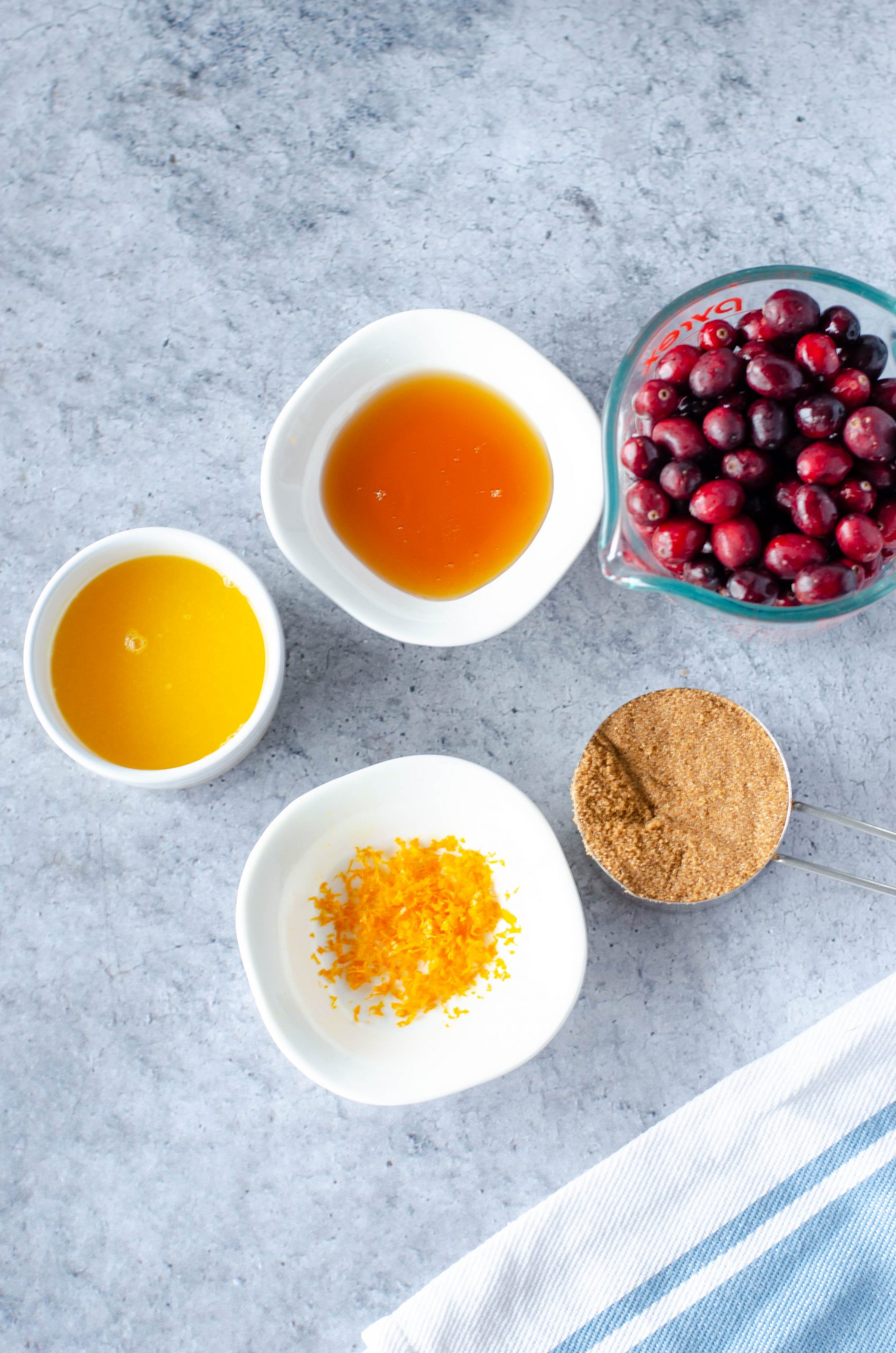 photo of cranberries, orange juice, orange zest, brown sugar, and honey in separate bowls