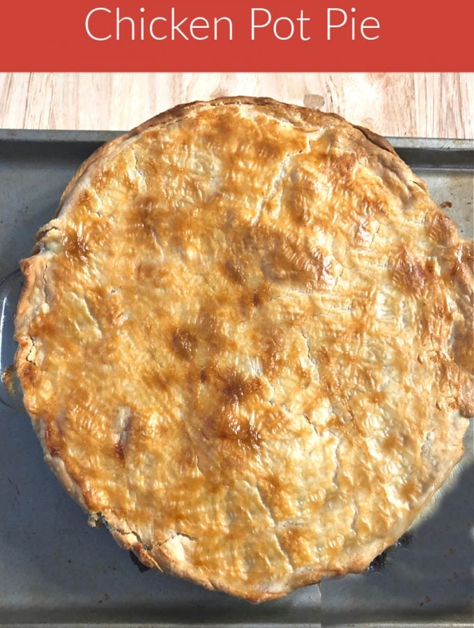 photo of a whole pot pie on a baking sheet on top of a wood table