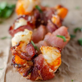 several pieces of bacon wrapped shrimp on a piece of paper