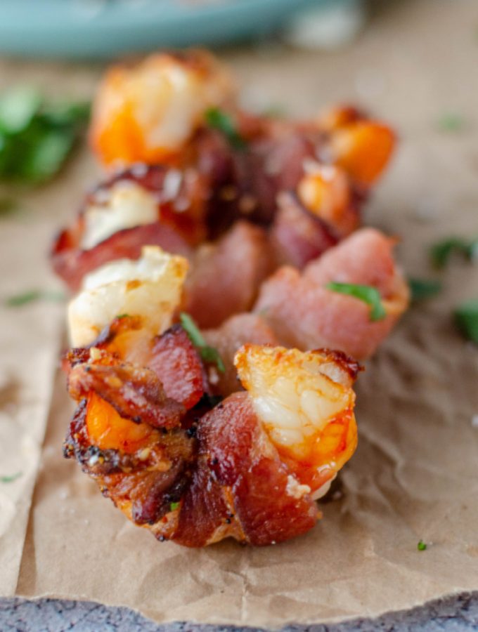 several pieces of bacon wrapped shrimp on a piece of paper