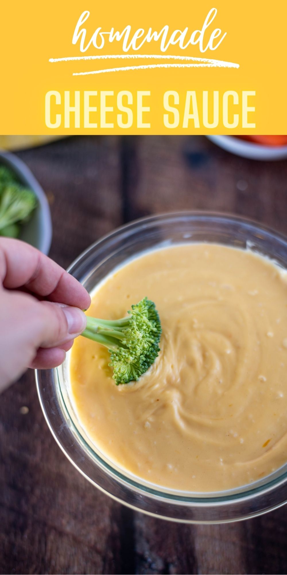 Cheese sauce in a bowl with a piece of broccoli being dipped into it 